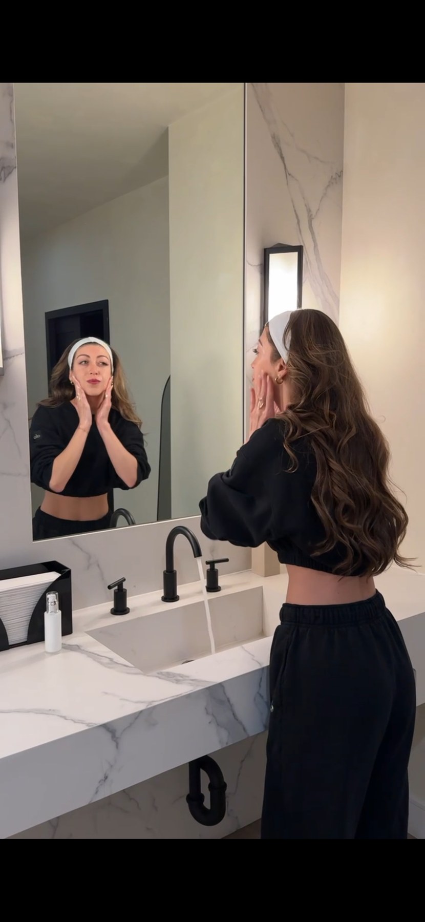 Guest checking her skin in a mirror inside LYEV Beverly Hills